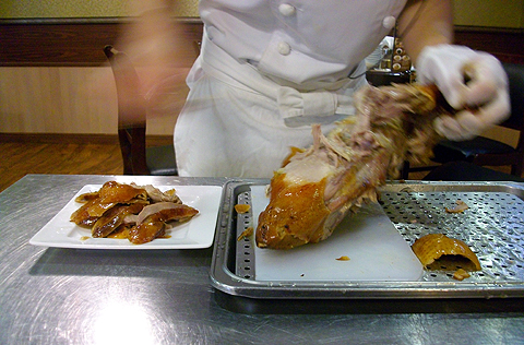 横浜中華街 北京火考鴨店で調理人が北京ダックを切り分ける